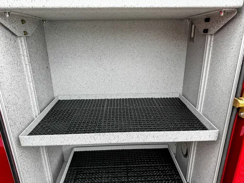 Deep lower compartment interior close-up with vent and side wiring.
